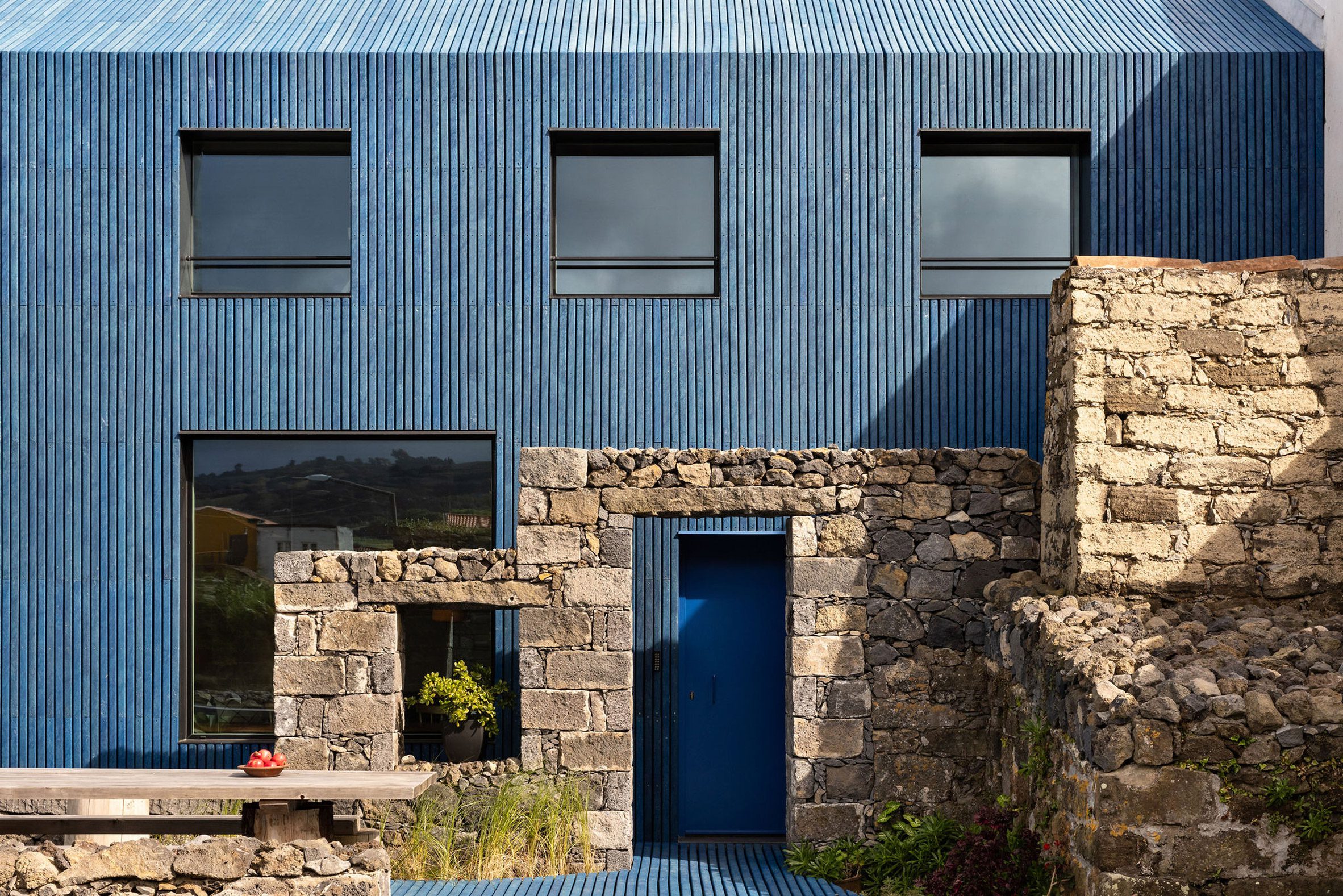 The Blue House se alza sobre los vestigios de una antigua taberna de balleneros abandonada en la década de 1980 en la bahía de Capelas.