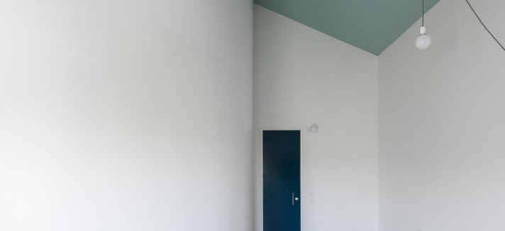 El azul de las puertas y las vigas vistas rompen con el blanco