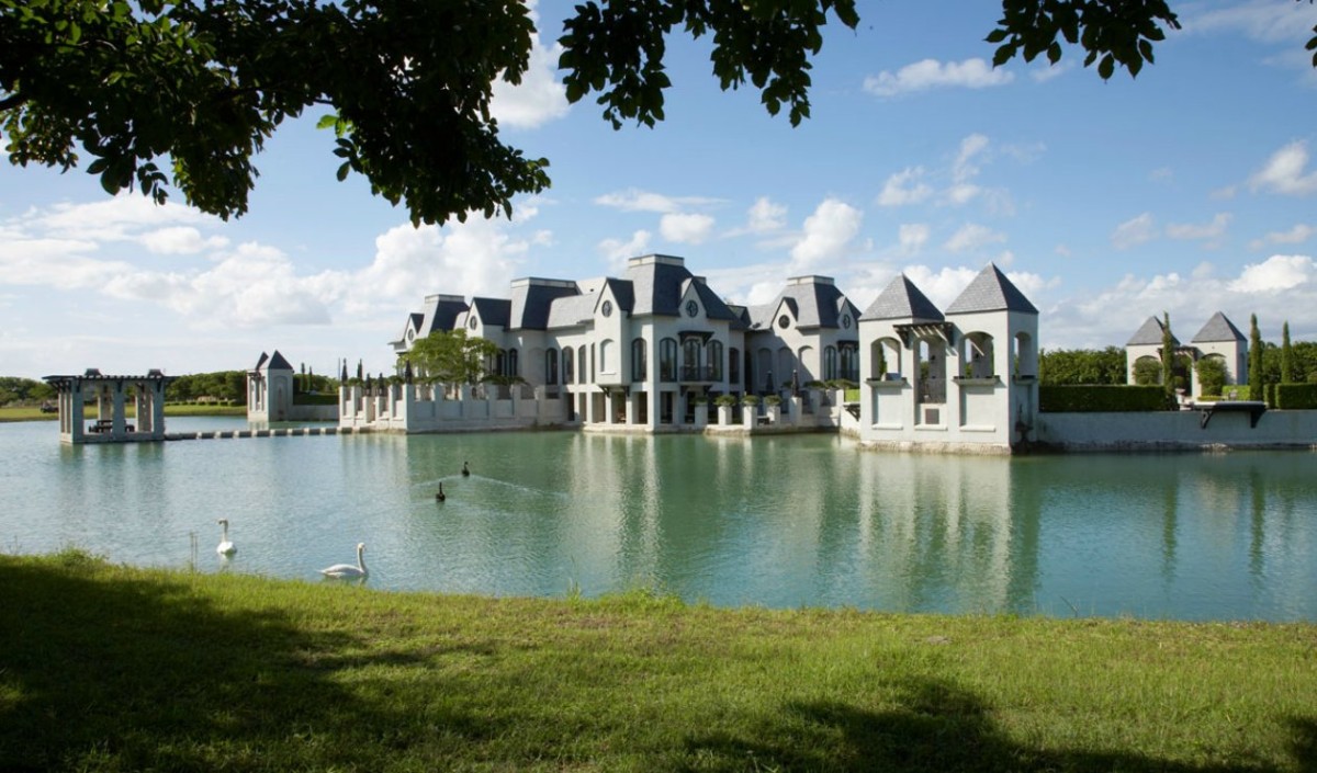 Castillo moderno rodeado de un lago con cisnes