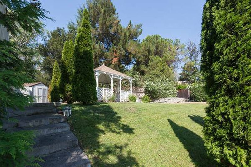 the-backyard-is-fairly-large-with-a-gazebo-that-sits-at-the-top-of-a-hill