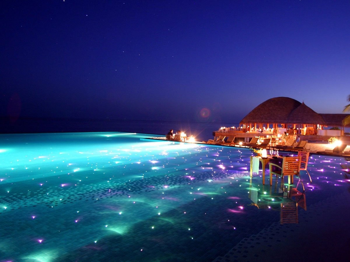 maldives-resort-huvafen-fushi-is-set-up-for-gorgeous-evening-swims-with-colored-lights-twinkling