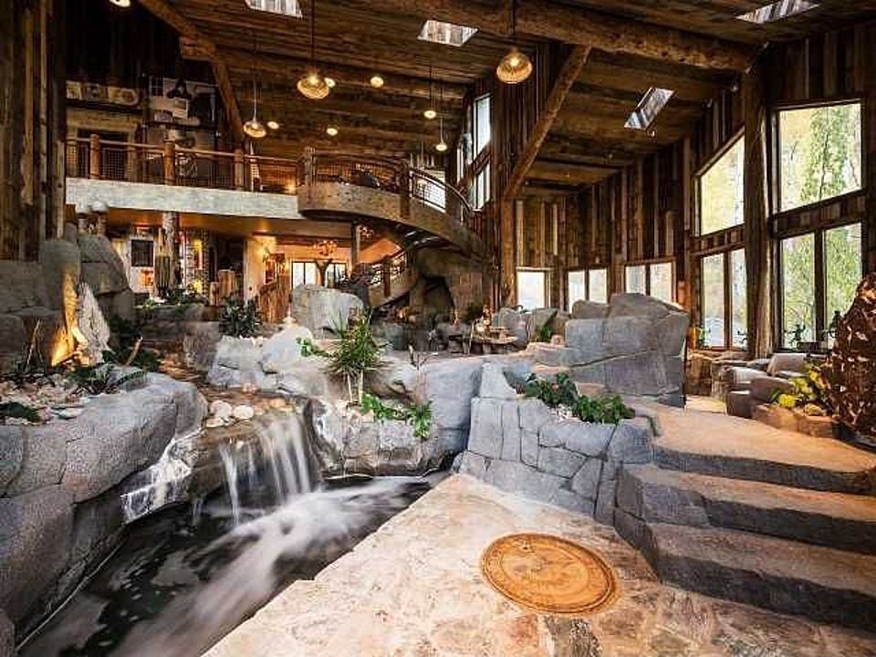 Casas de ensueño: una mansión en la montaña que pasaría desapercibida si no fuera por el río que cruza el salón