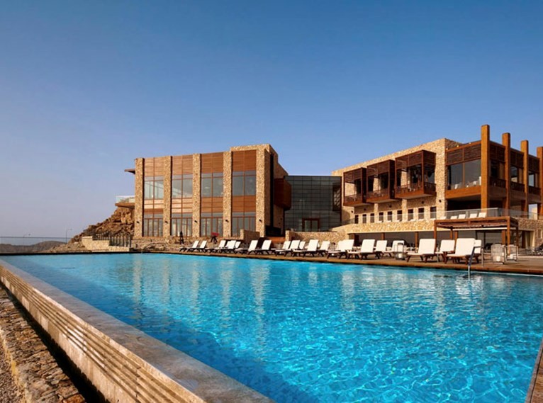 La piscina está en el edifico con las zonas comunes