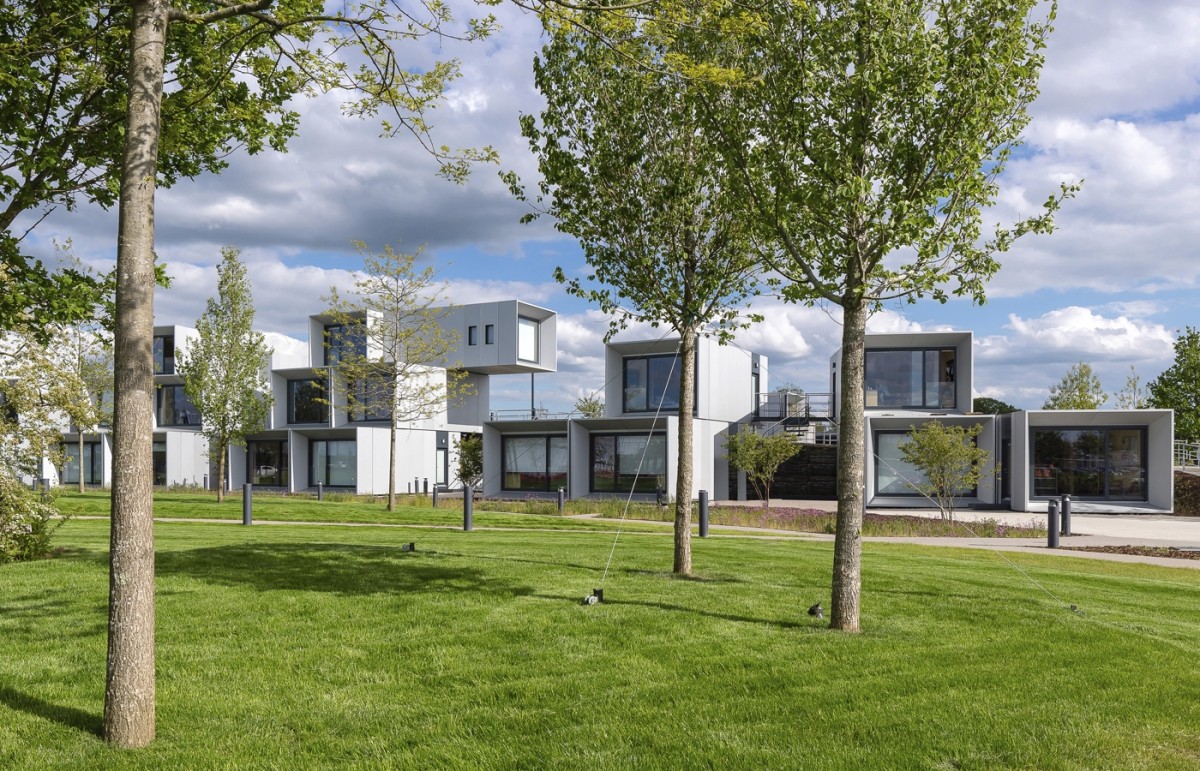 El edificio está rodeado de césped y árboles