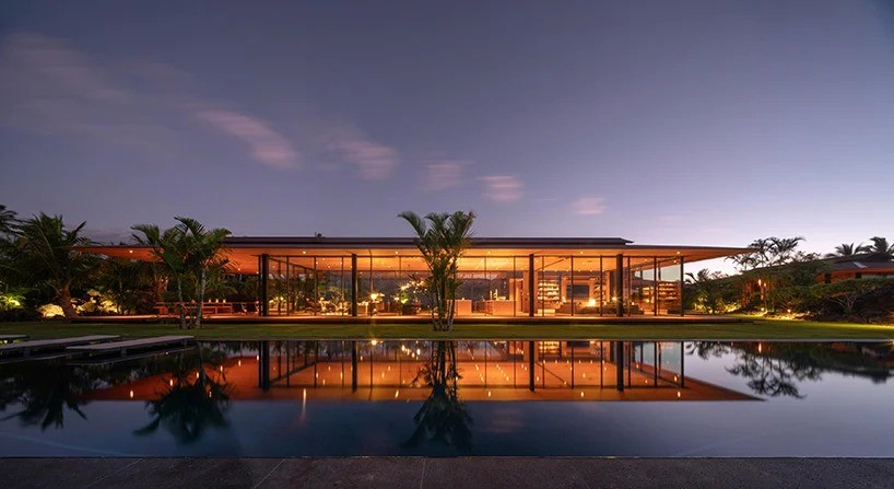 Una casa de lujo de madera y vidrio que parece flotar sobre la hierba en Hawai