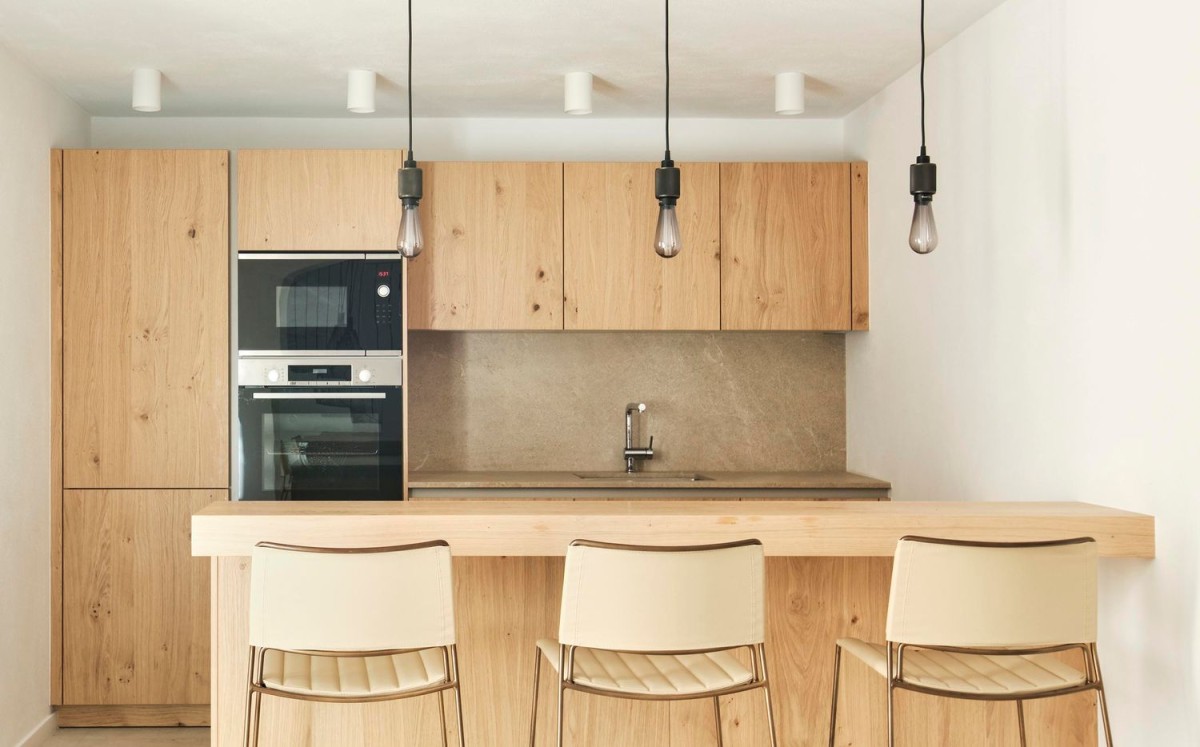 The sleek kitchen is finished with natural wooden units The sleek kitchen is finished with natural wooden units
