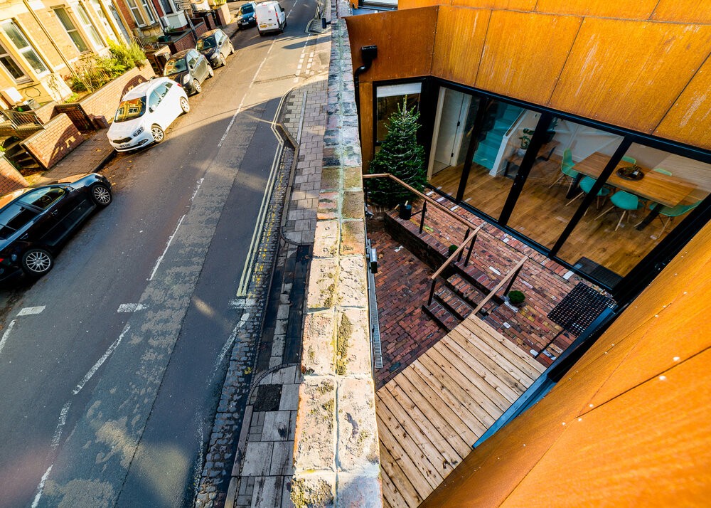 El moderno revestimiento contrasta con el muro de ladrillo