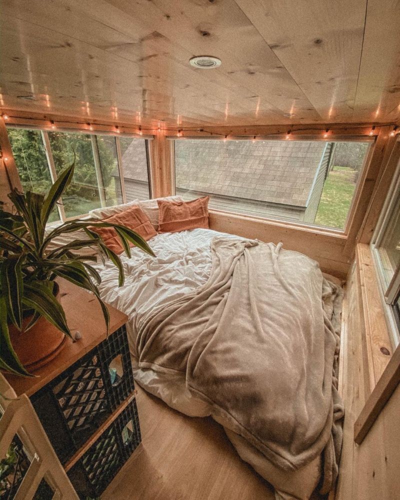 Una gran cama rodeada de ventanas