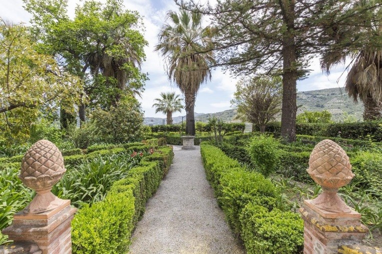 Con palmeras centenarias, plantas exóticas y cipreses antiguos