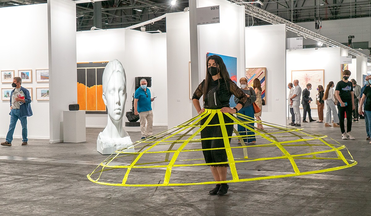 Artista realizando una performance con una escultura de Jaume Plensa al fondo