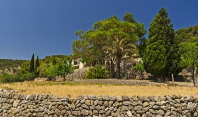 Rodeada de árboles y un muro de piedra