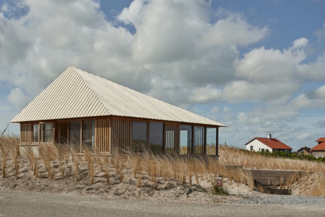 Una casa prefabricada para uso vacacional que emerge de las dunas