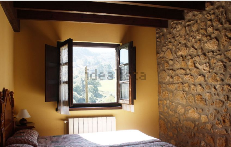 Con paredes de piedra y vigas vistas