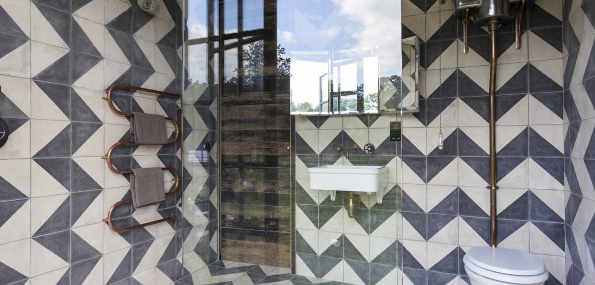 Ducha con mampara y baldosas hidráulicas con motivos geométricos
