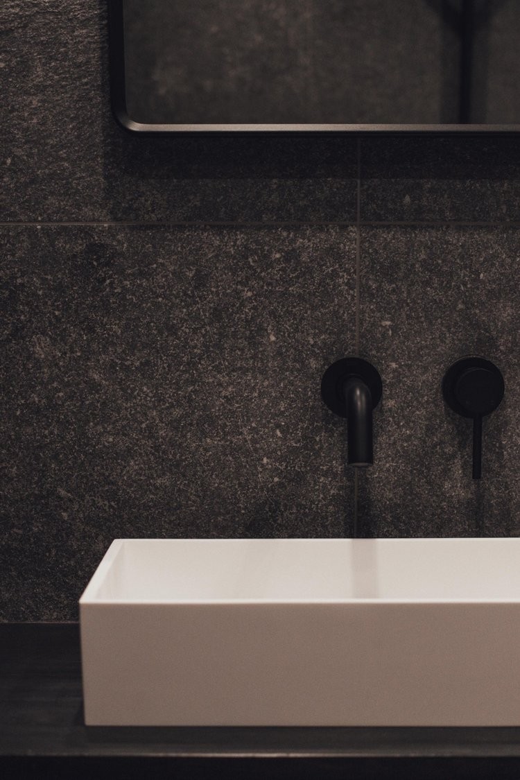 Lavabo del cuarto de baño con tonos blancos y negros