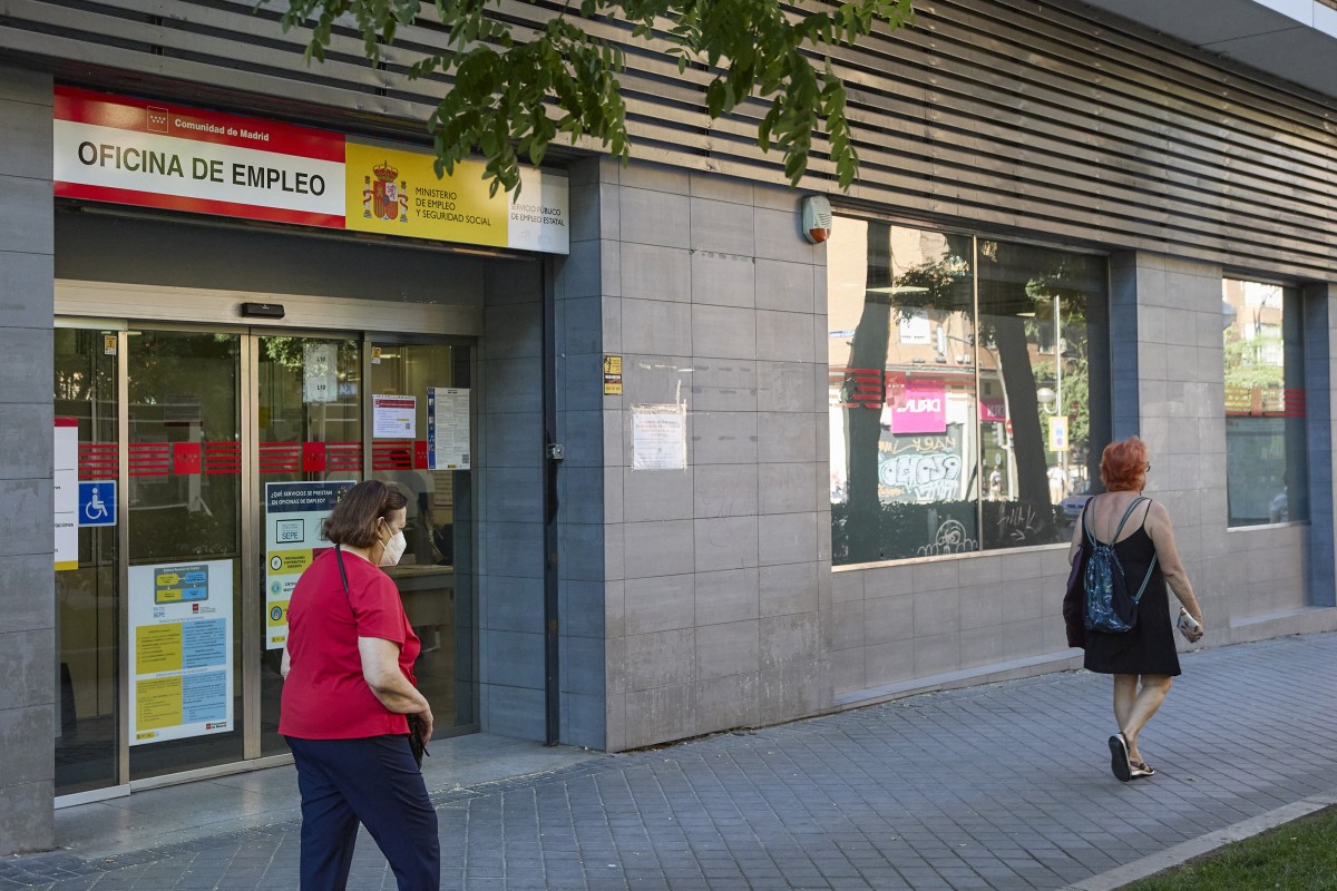 Archivo - Varias personas pasan por delante de una oficina de empleo
