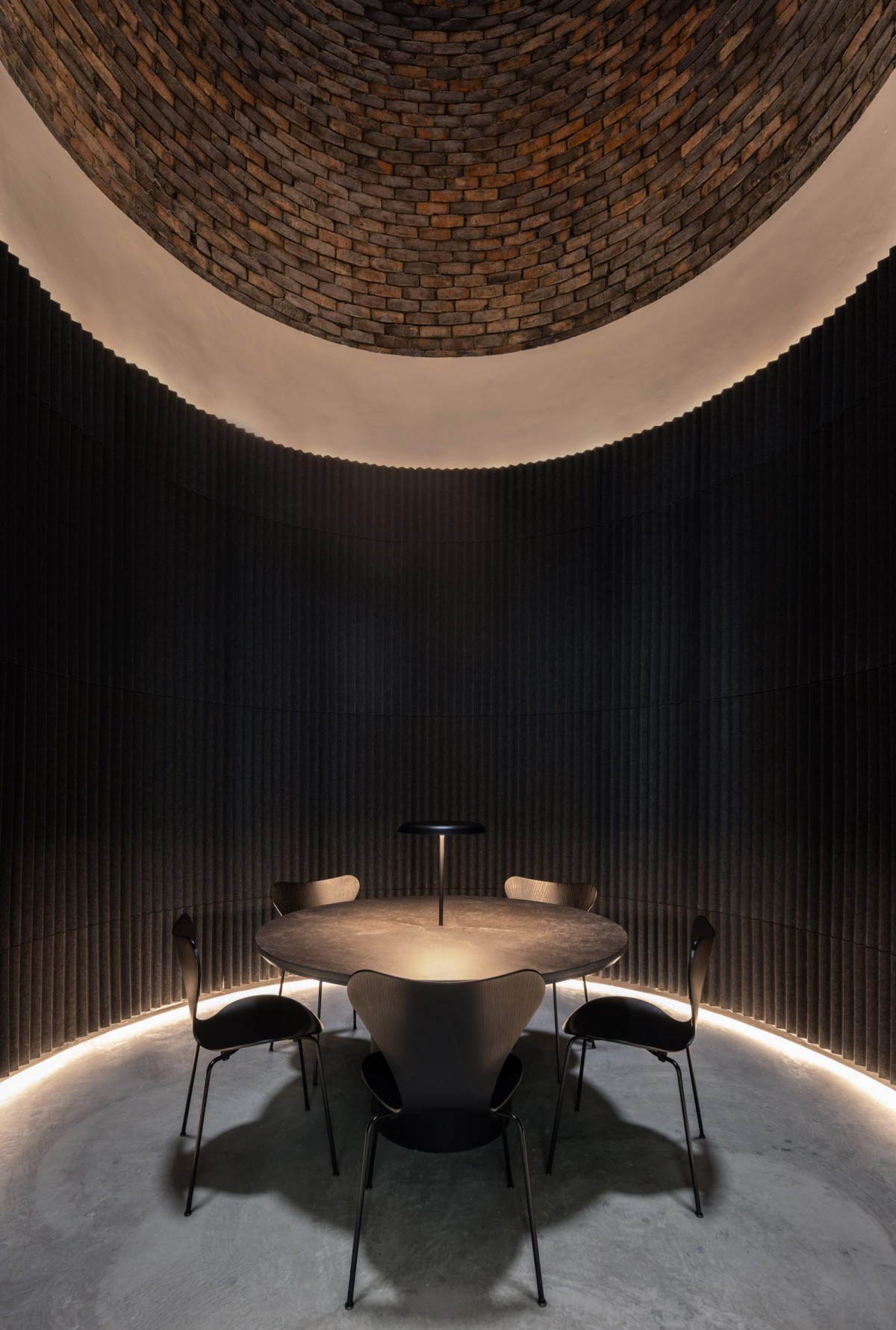 Una sala de reuniones atmosférica se sitúa en la base de la chimenea