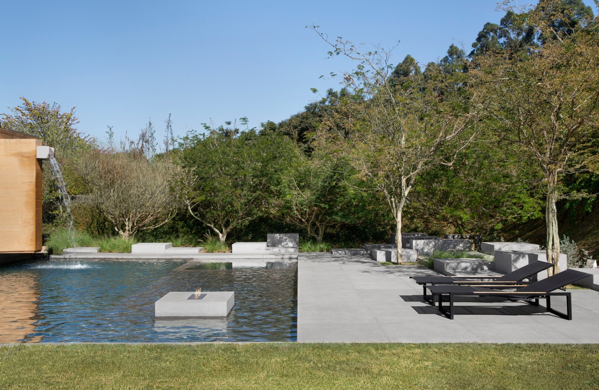 Piscina con hamacas y árboles al fondo