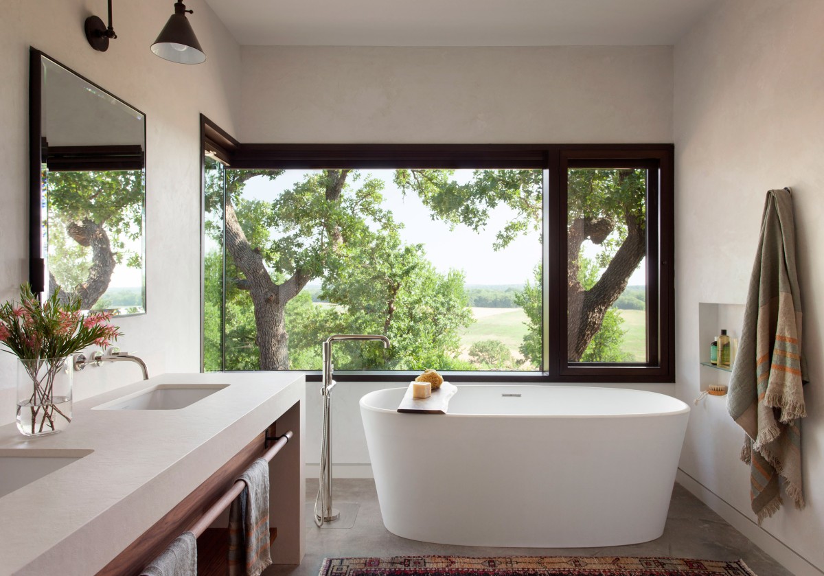 El baño tiene vistas hacia los árboles del exterior.