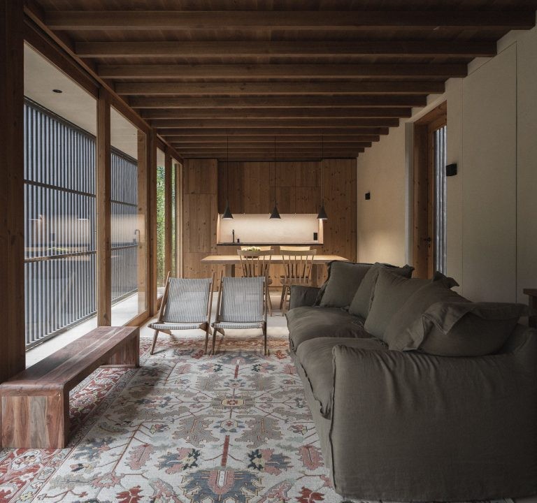 Salón con cocina al fondo y ventanales