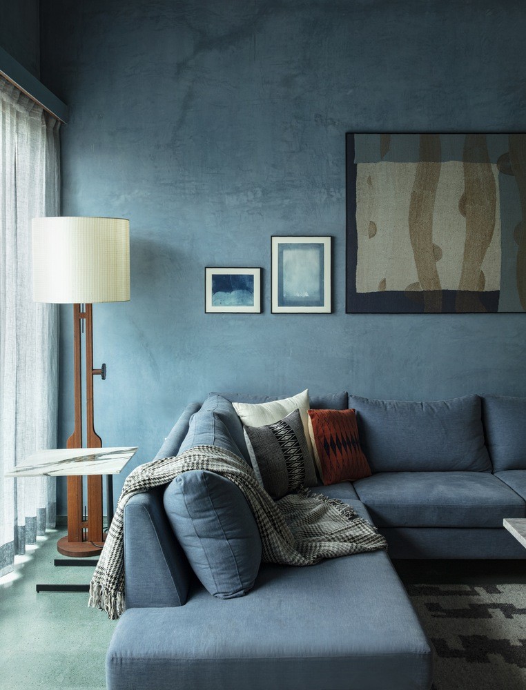 Detalle del salón con sofá y lámpara