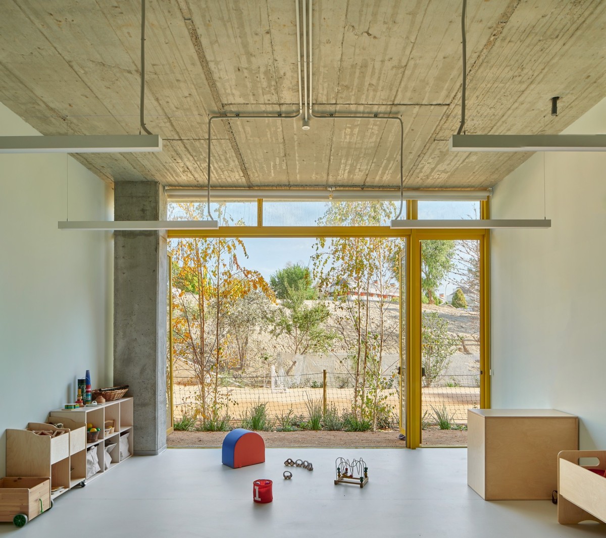 Interior de un aula con mobiliario y ventanal