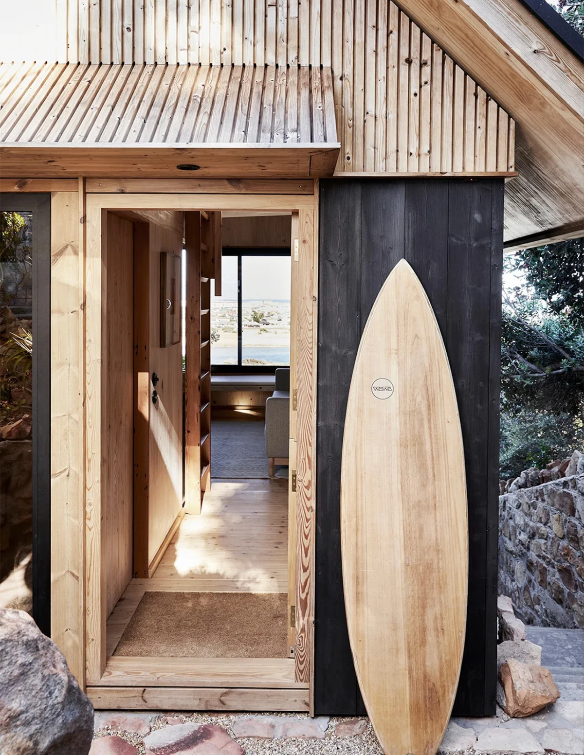 Entrada con una tabla de surf apoyada junto a la puerta