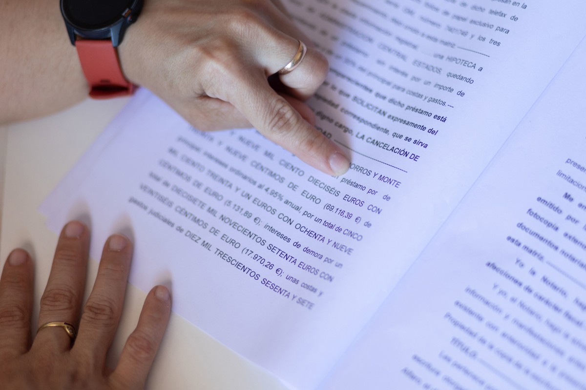 Una mujer señala una escritura de compraventa de una hipoteca, a 30 de mayo de 2022, en Madrid (España). 