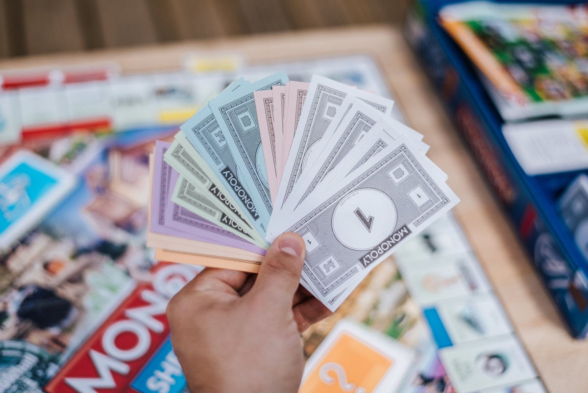 Dinero del Monopoly en la mano