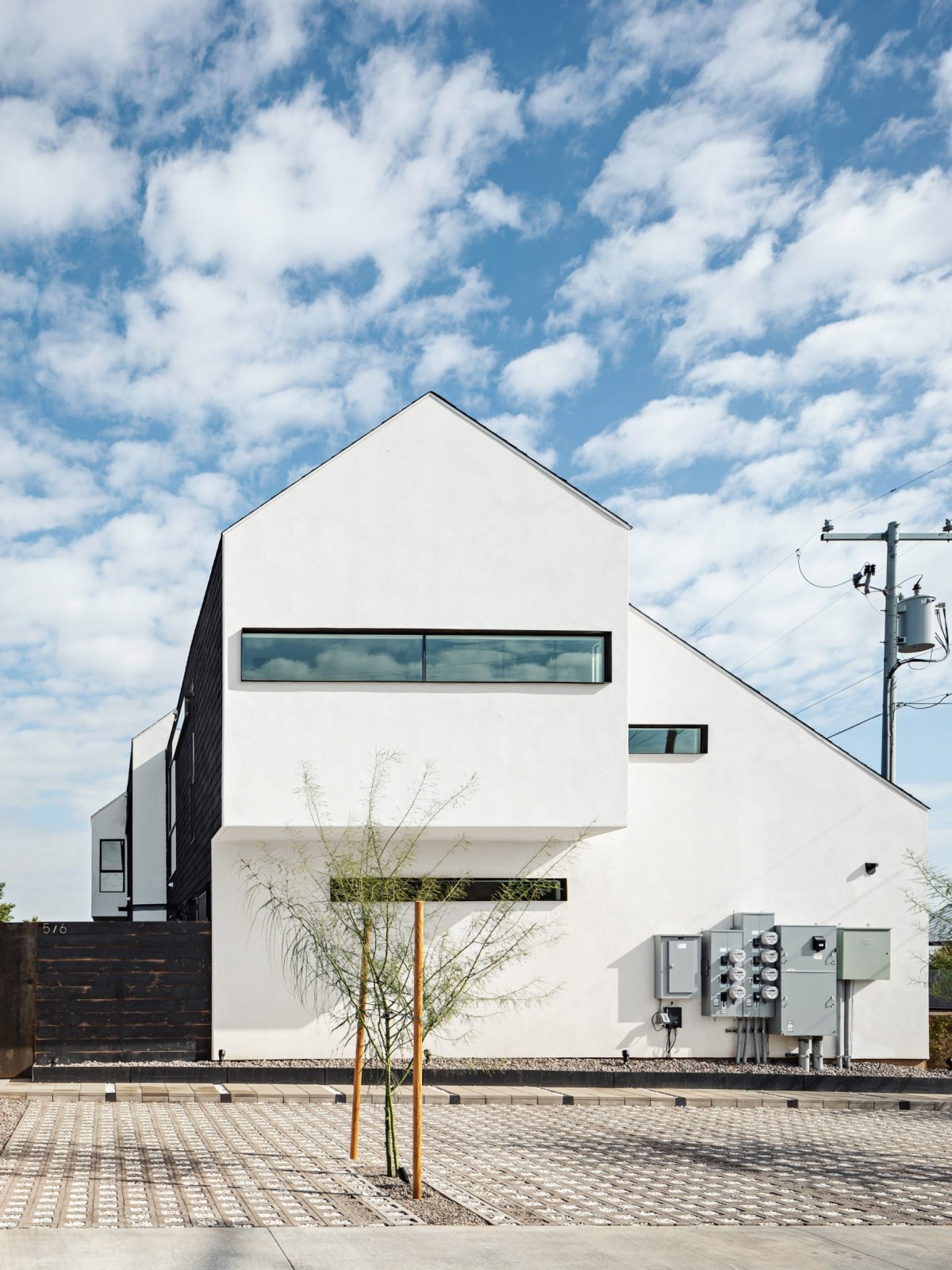 La fachada oeste está revestida de estuco vainilla, contrastando su tono con el resto del bloque