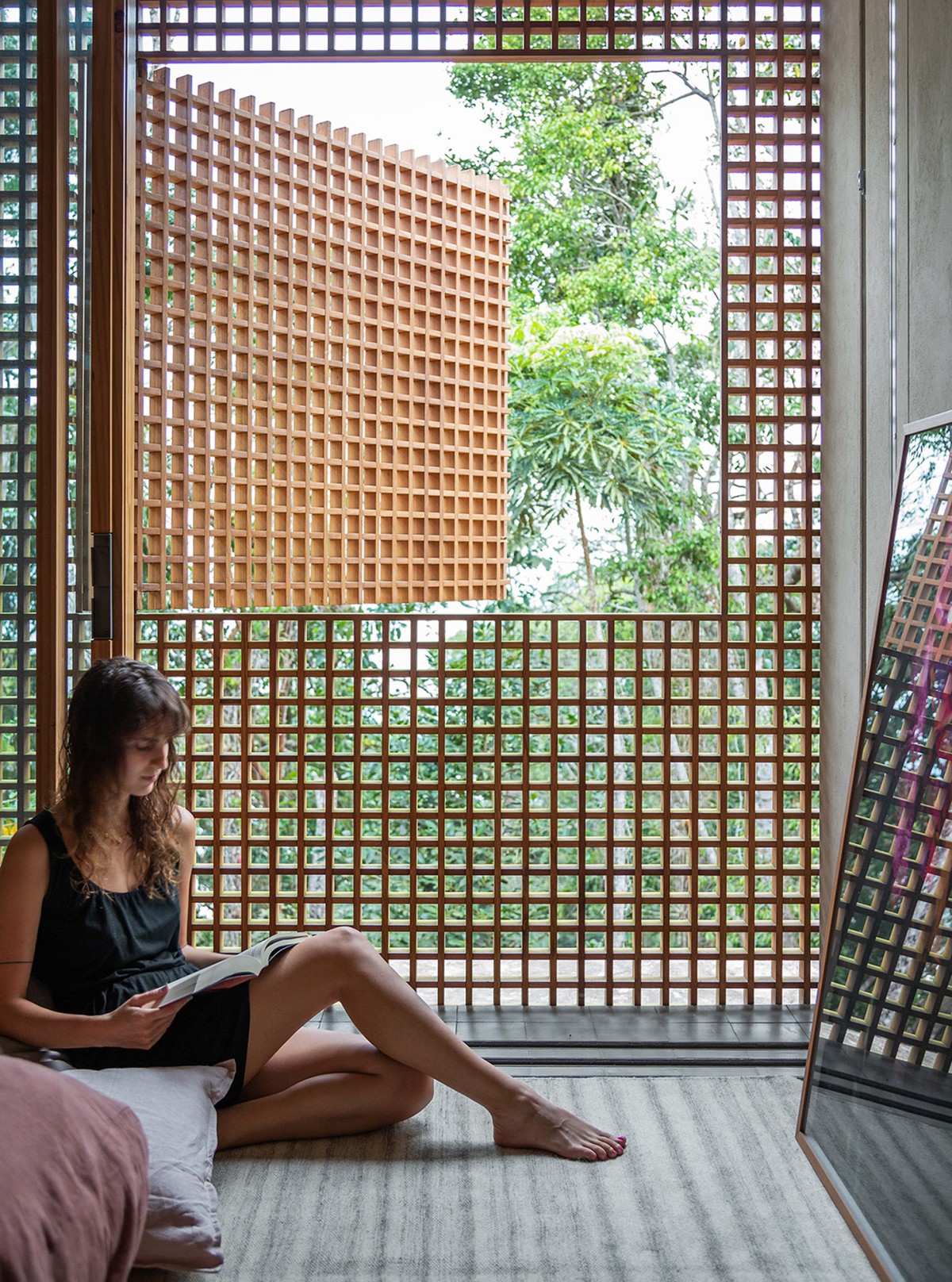 Rincón del dormitorio con mujer leyendo