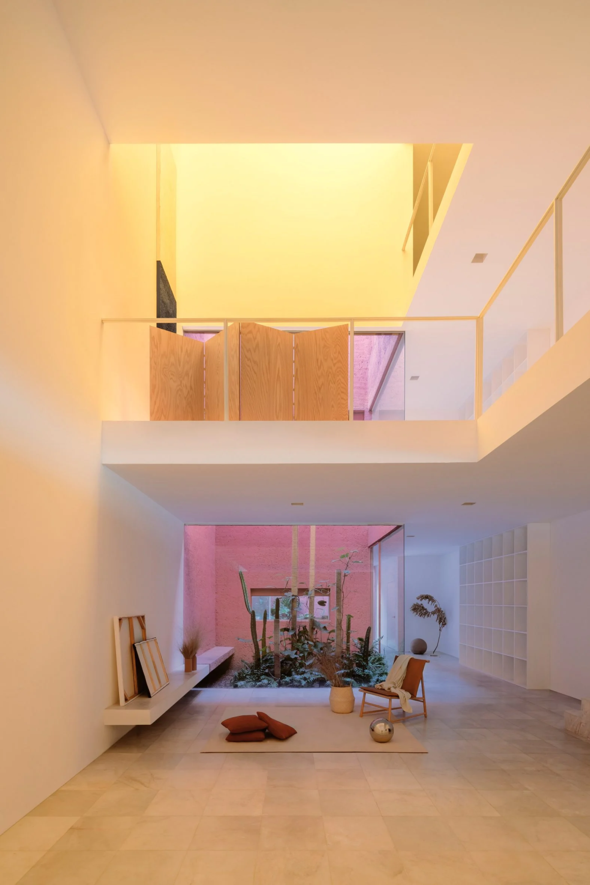La altura generada por la abertura de varias plantas en el interior, amortigua la estrechez de la vivienda.