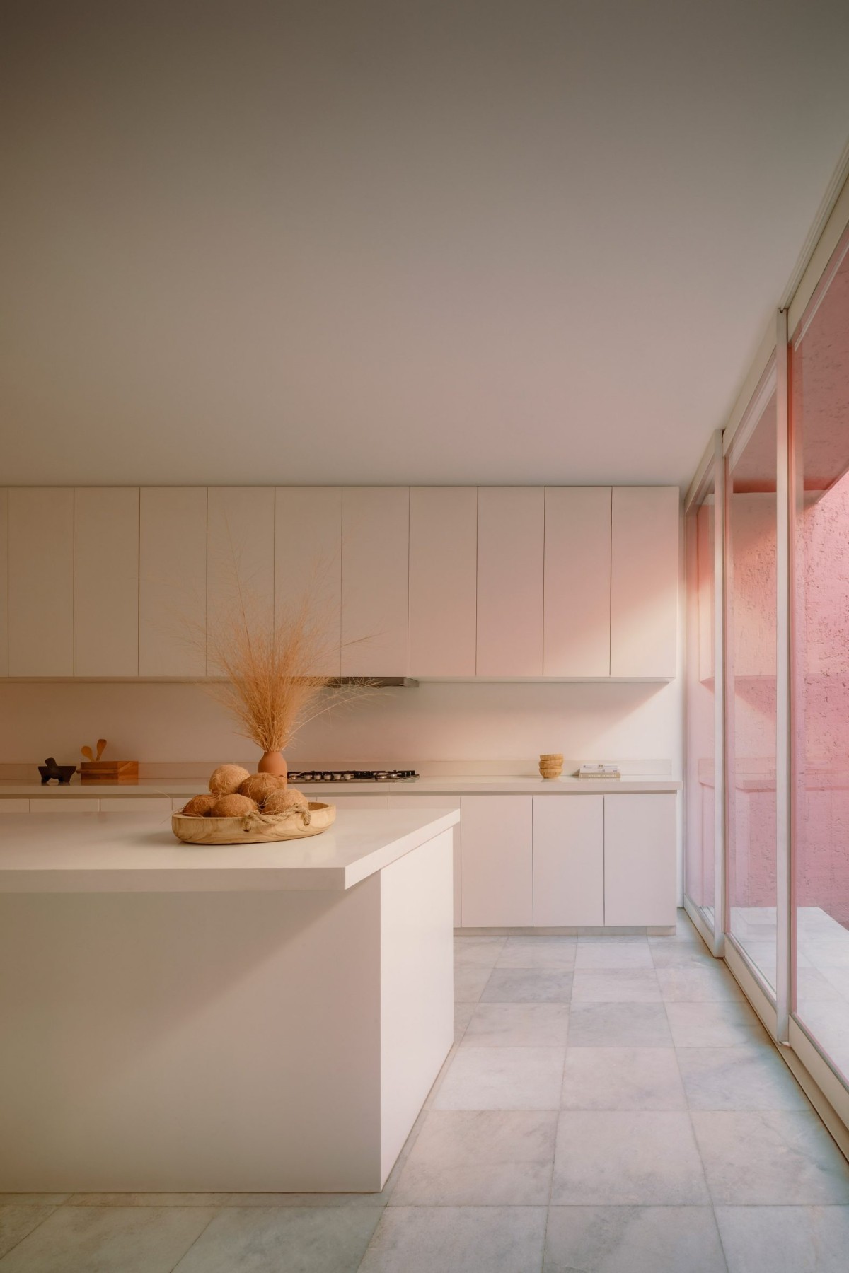 Aunque en el interior destacan los tonos blancos, el revestimiento rosa del patio endulza los espacios comunes.