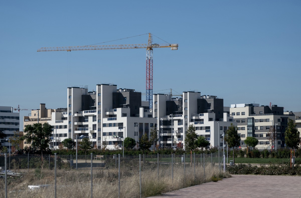 Archivo - Una grúa en una zona de construcción de viviendas nuevas