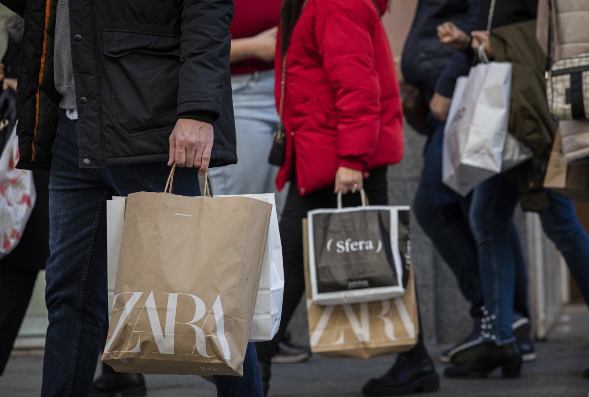 Archivo - Varias personas con bolsas de la compra en una calle centrica. 