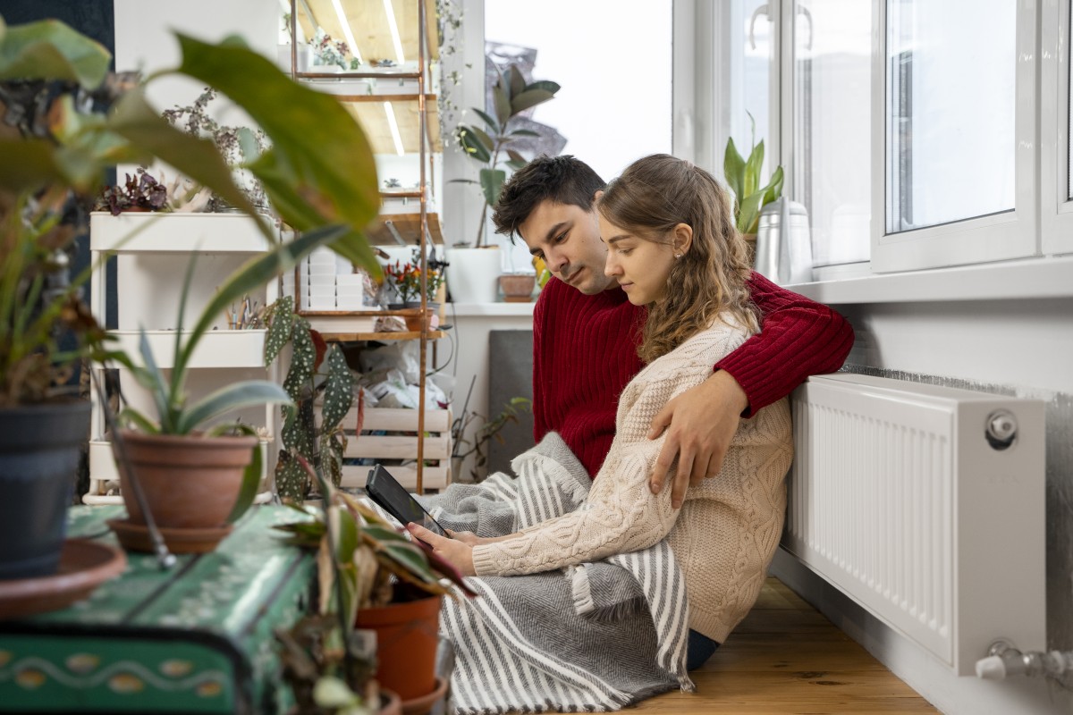 Primer plano de un termostato de radiador con mano de mujer