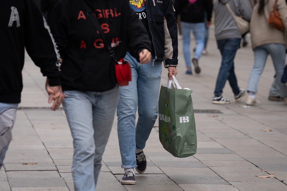 Archivo - Un hombre sujeta una bolsa con compras durante la campaña de Navidad, a 1 de diciembre de 2023, en Barcelona, Catalunya (España). 