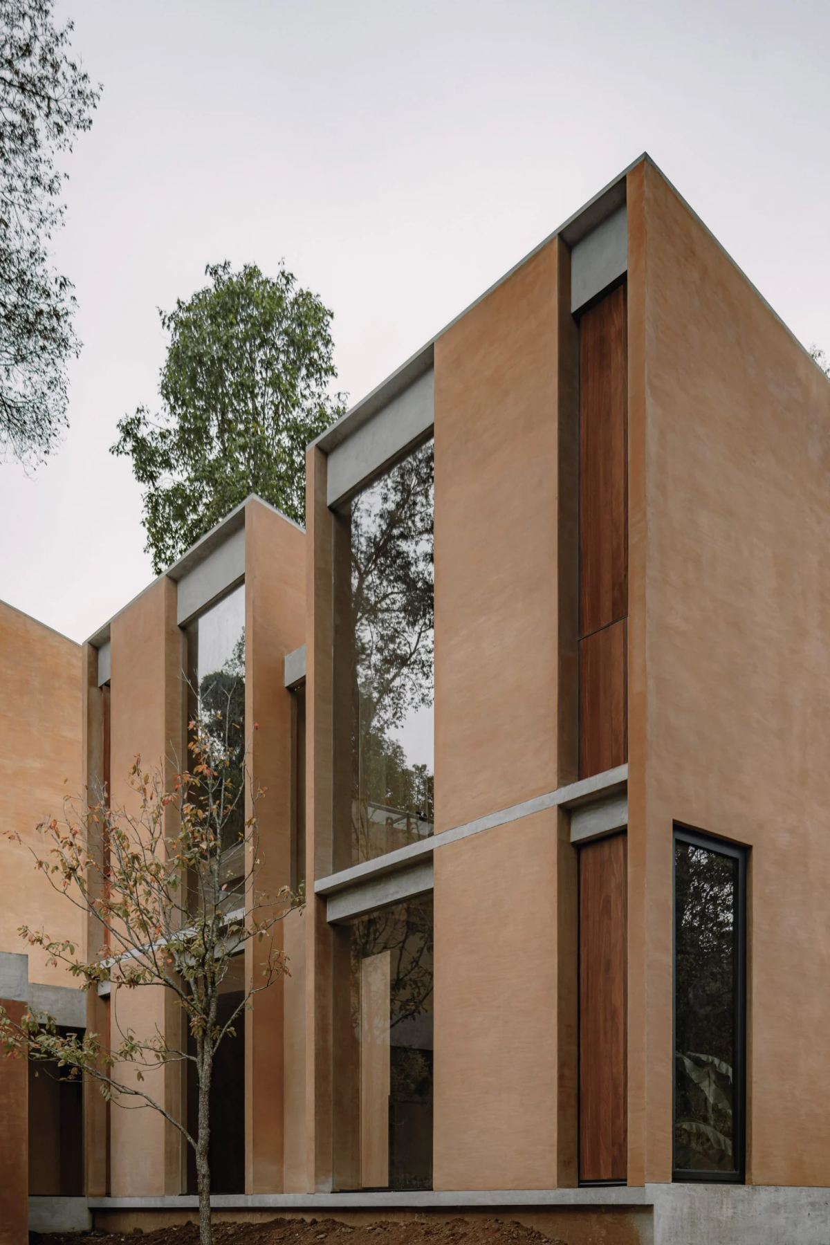 Las grandes ventanas del techo al suelo permiten que los interiores se fundan con la naturaleza que rodea las viviendas.