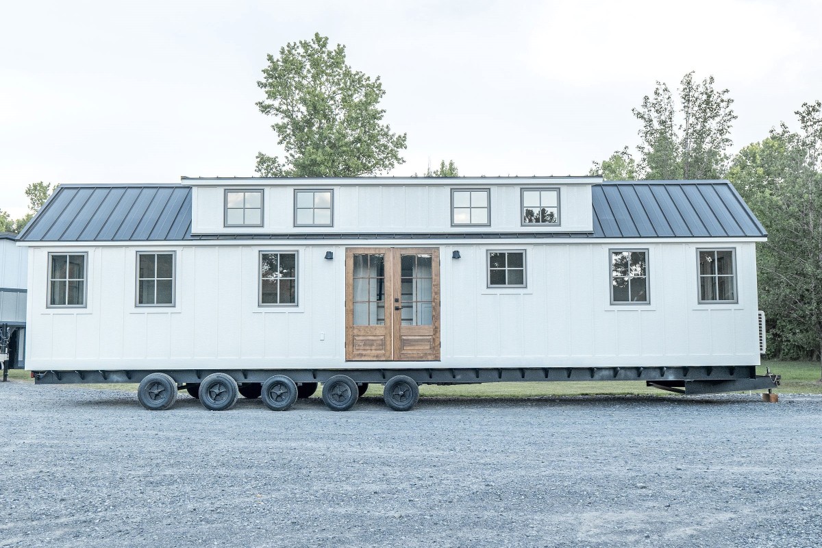 El exterior de la casa está acabado con un revestimiento de tablas y tablones rematado con un tejado de metal lo que le confiere un estilo casa de campo.