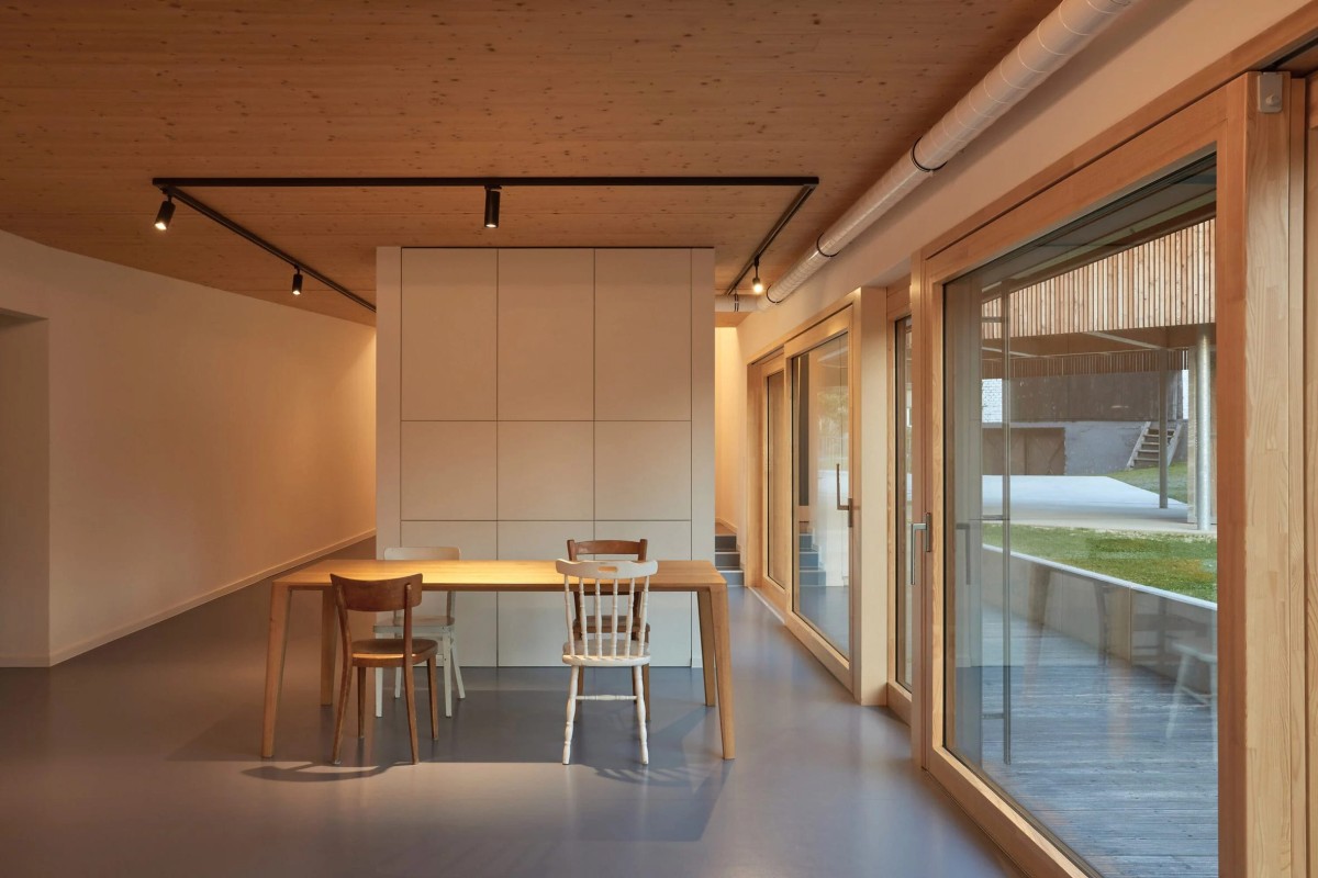 La cocina, el salón y el comedor disponen de grandes muros acristalados que abren hacia el jardín y el molino, simulando que son parte de la decoración.