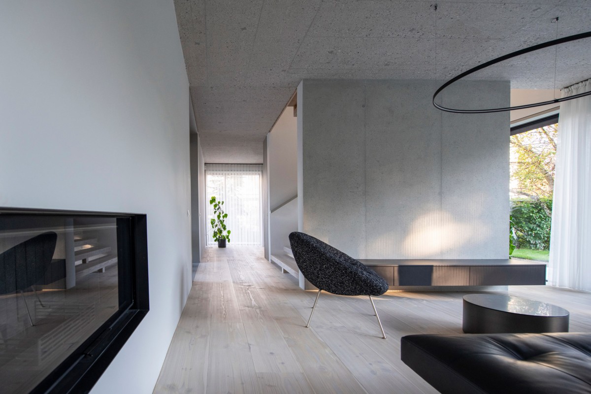 Las paredes y techos de hormigón visto, junto con los suelos de madera clara, crean un ambiente acogedor y contemporáneo en el interior.