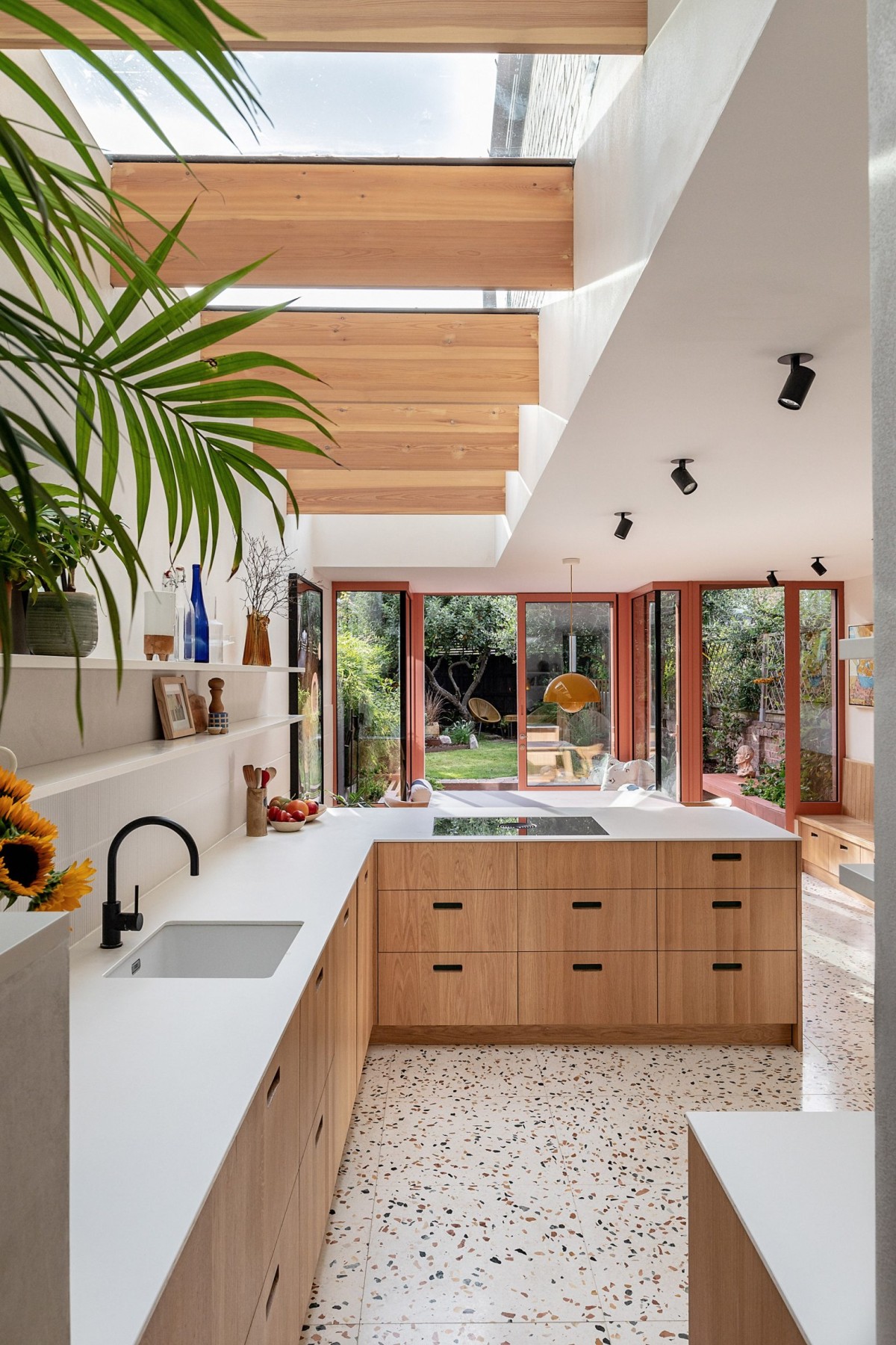 La ampliación alberga una luminosa cocina abierta y un comedor, ambos iluminados por una extensa claraboya.