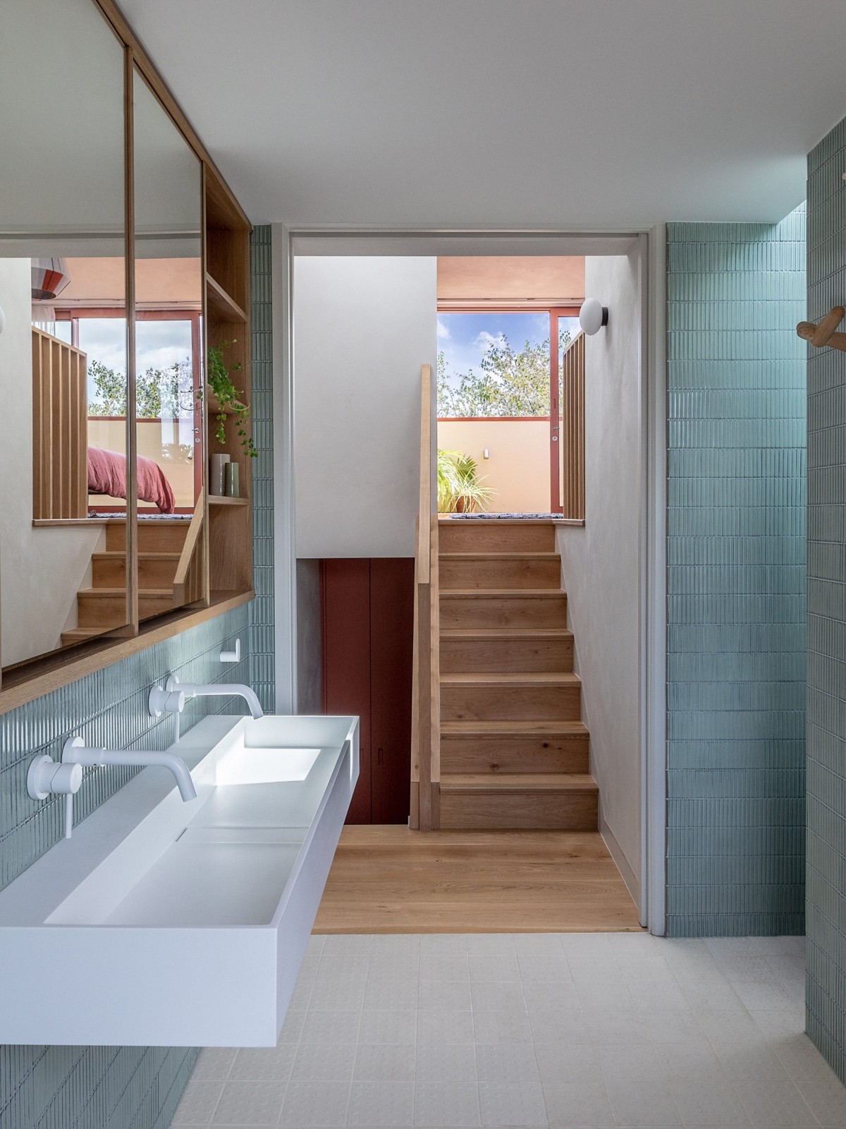 El baño del dormitorio en suite está elaborado con azulejos azules y se conecta con la habitación mediante una pequeña escalera.