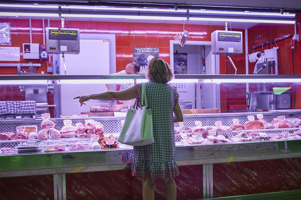 Una mujer comprando en una carnicería