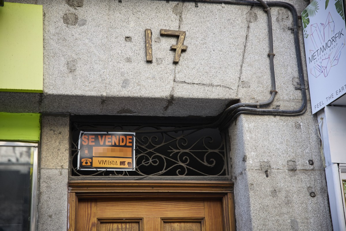 Cartel de una vivienda en venta en el escaparate en el barrio de Almagro