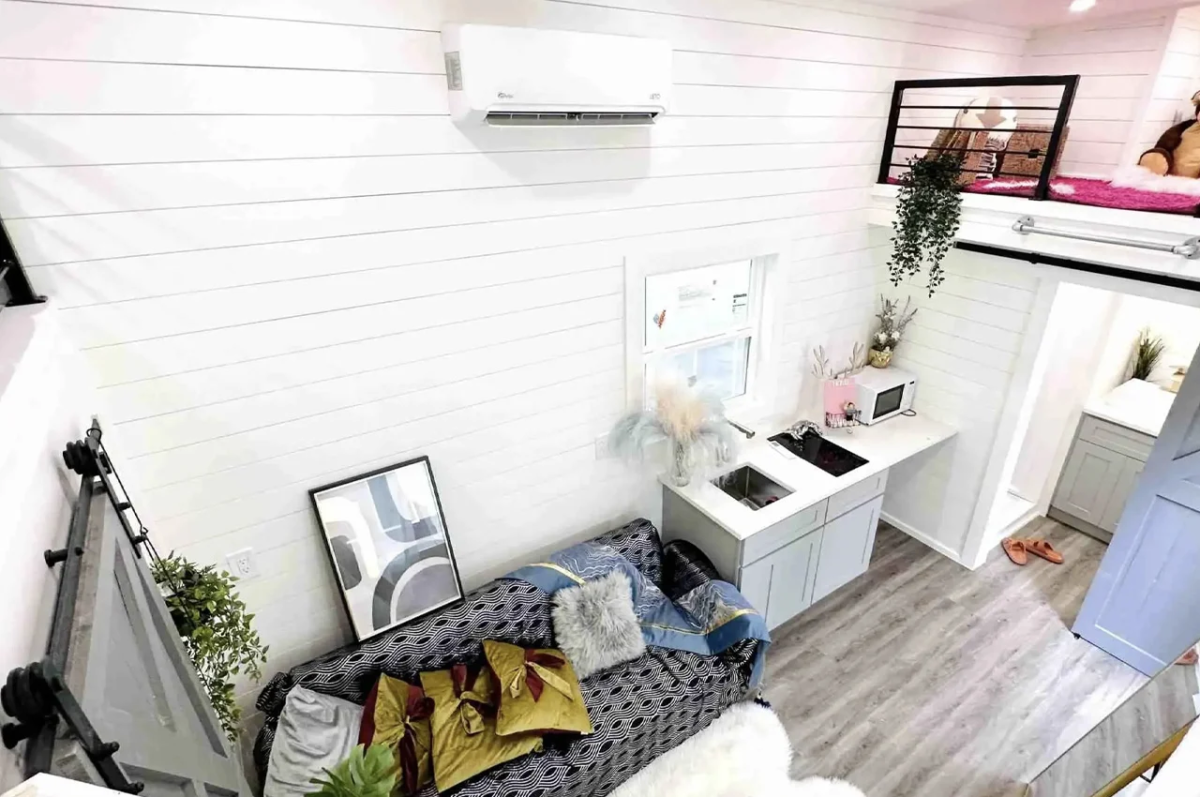 En el espacio central se encuentra la sala de estar, la cual cuenta con un sofá, y la cocina equipada.