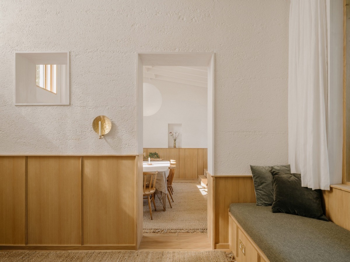 El interior presenta una paleta de colores neutros, con paredes pintadas en un tono claro de arcilla y paneles de madera.