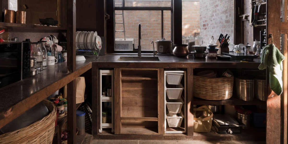 La cocina y el dormitorio principal ocupan espacios más íntimos con techos más bajos y paredes revestidas de madera oscura.