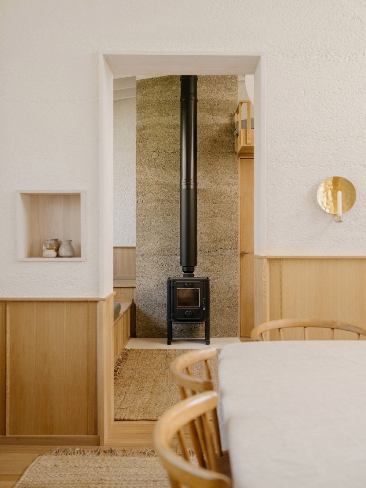 Adyacente al espacio principal de trabajo, una segunda sala ofrece una zona de estar informal que cuenta con una chimenea de hierro y un sofá en forma de L.