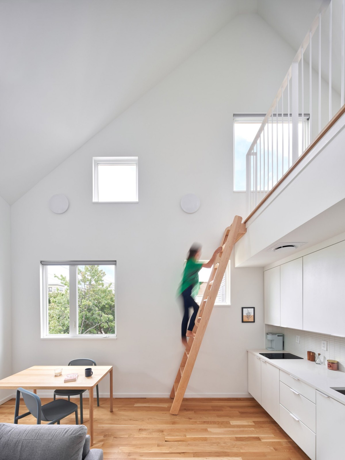 El interior del edificio alberga ocho apartamentos luminosos con suelos de madera y armarios blancos.